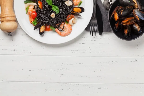 黑面意大利面配海鲜 西红柿和罗勒 带有复制空间的顶视图平面布局 — 图库照片