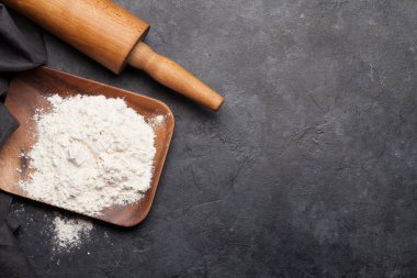 Yuvarlanan iğne ve un, taş masanın üzerinde. Ev yapımı yemek konsepti. Üst görünüm düzlüğü kopyalama alanı ile yatıyordu