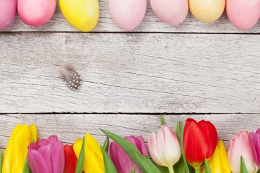 Paskalya tebrik kartı, üzerinde paskalya yumurtaları ve lale çiçekleri var. Üst görünüm düzlüğü kopyalama alanı ile yatıyordu