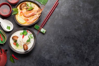 Tom Yum ve Tom Kha geleneksel deniz ürünleri, tavuk, mantar, hindistan cevizi sütü ve sıcak baharatlı Tayland çorbaları. Yeşil çaydanlık ve kase ile. Kopyalama alanı olan üst görünüm