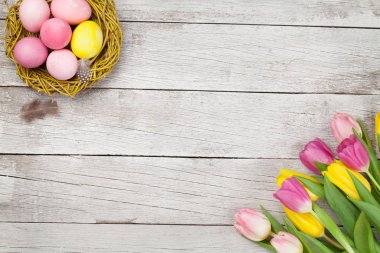 Paskalya tebrik kartı, üzerinde paskalya yumurtaları ve lale çiçekleri var. Üst görünüm düzlüğü kopyalama alanı ile yatıyordu