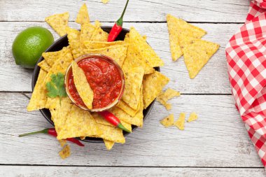 Mexican nachos chips with salsa sauce. Top view flat lay on wooden table