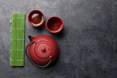 Çaydanlıkta Japon çayı ve taş masada fincanlar. Asya yemekleri konsepti. Üst görünüm düzlüğü kopyalama alanı ile yatıyordu