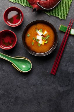 Tofulu ve taze soğanlı Miso geleneksel Japon çorbası. Çaydanlıkta yeşil çay ve kâselerle. Kopyalama alanı olan üst görünüm