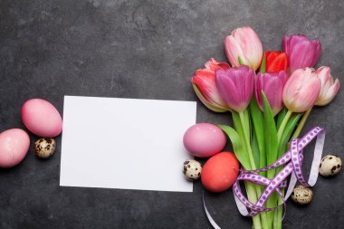 Paskalya tebrik kartında paskalya yumurtaları ve lale çiçekleri var. Üst görünüm düzlüğü kopyalama alanı ile yatıyordu