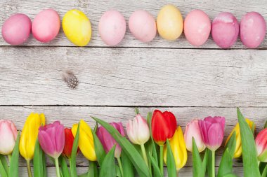 Paskalya tebrik kartı, üzerinde paskalya yumurtaları ve lale çiçekleri var. Üst görünüm düzlüğü kopyalama alanı ile yatıyordu