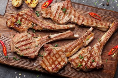 Kesme tahtasında ızgara kuzu kaburgası. Baharatlı ve baharatlı kuzu pirzolası. Üst görünüm