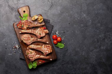 Kesme tahtasında ızgara kuzu kaburgası. Baharatlı ve baharatlı kuzu pirzolası. En üstteki tablo üzerinde kopya alanı ile birlikte görünüm