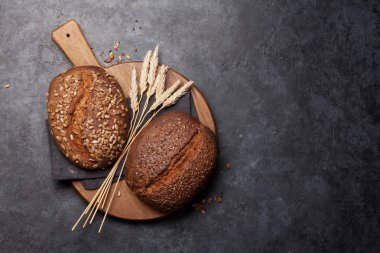 Various homemade bread with seeds on stone table. Top view flat lay with copy space