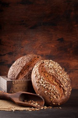 Tohumlu çeşitli ev yapımı ekmek. Kopya alanı olan ahşap duvarın önünde.