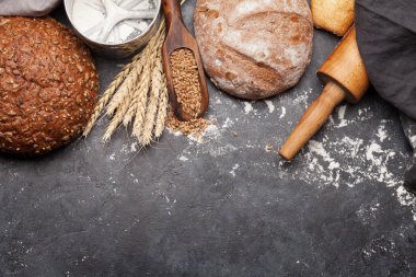 Buğdaylı, unlu ve çatal bıçaklı çeşitli ekmekler. Ev yapımı yemek konsepti. Üst görünüm düzlüğü kopyalama alanı ile yatıyordu