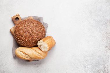 Taş masada çeşitli ekmekler. Üst görünüm düzlüğü kopyalama alanı ile yatıyordu