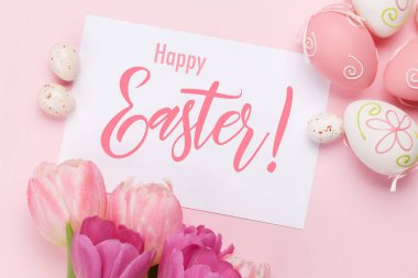 Paskalya tebrik kartı, pembe arka planda paskalya yumurtaları ve lale çiçekleri. Üst görünüm düzlüğü