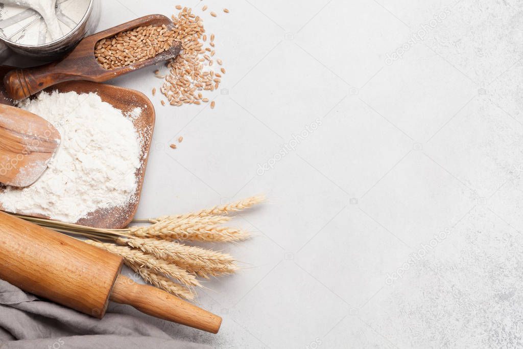 Various bread ingredients. Wheat, flour and cooking utensils on stone table. Top view flat lay with copy space