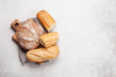 Taş masada çeşitli ekmekler. Üst görünüm düzlüğü kopyalama alanı ile yatıyordu