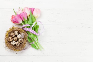 Paskalya tebrik kartı, üzerinde paskalya yumurtaları ve lale çiçekleri var. Üst görünüm düzlüğü kopyalama alanı ile yatıyordu