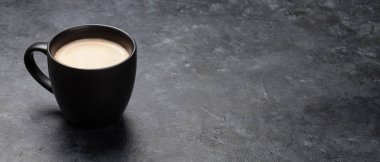 Kahve fincanı, üzerinde fotokopi alanı olan koyu taş bir masada.