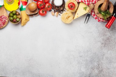 İtalyan mutfağı malzemeleri. Makarna, peynir, domates, zeytin ve şarap. Üst görünüm düz taş masa üzerinde kopya alanı ile yatıyordu