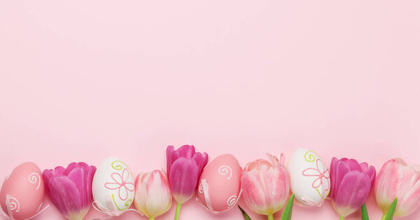 Easter greeting card with easter eggs and tulip flowers over pink background. Top view flat lay with space for your greetings