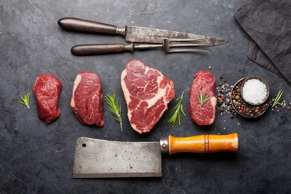 各种新鲜的生鲜牛肉蒸肉和香料放在石桌上 顶视图平铺 — 图库照片