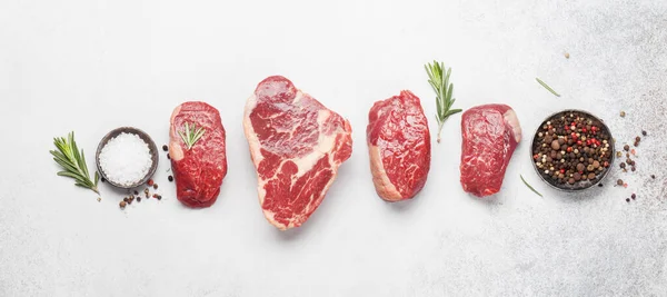 Verschiedene Frische Rohe Rindfleischsteaks Mit Gewürzen Auf Einem Steintisch Draufsicht — Stockfoto