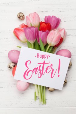 Paskalya tebrik kartı, üzerinde paskalya yumurtaları ve lale çiçekleri var. Üst görünüm düzlüğü
