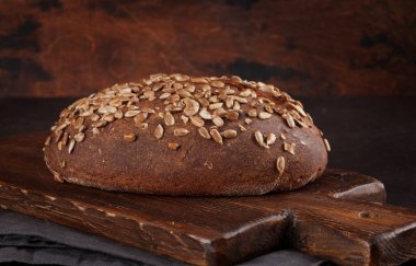 Tohumlu ev yapımı ekmek. Tahta duvarın önünde