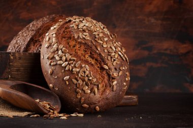 Tohumlu çeşitli ev yapımı ekmek. Kopya alanı olan ahşap duvarın önünde.