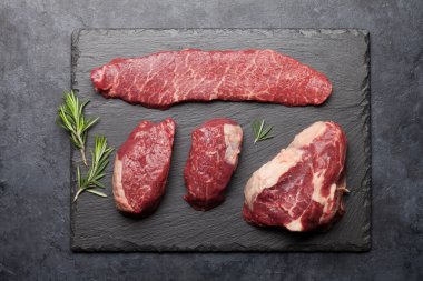 Taş tahtada baharatlı taze çiğ biftek çeşitleri. Üst görünüm düzlüğü