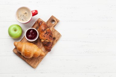 Kahve ve kruvasanla kahvaltı. Tahta masanın üst manzarası. Kopyalama alanı olan düz