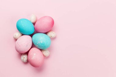 Paskalya tebrik kartı ve pembe arka planda renkli paskalya yumurtaları. Tebrik etmek için en üstteki dairede yer var.