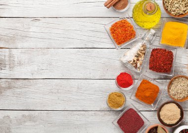 Beyaz ahşap masada çeşitli baharatlar var. Hint mutfağı. Üst görünüm düzlüğü kopyalama alanı ile yatıyordu