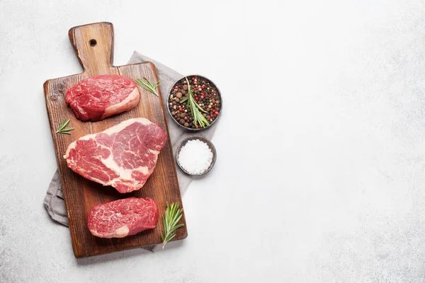 Verscheidenheid Van Verse Rauwe Biefstuk Met Specerijen Stenen Achtergrond Bovenaanzicht — Stockfoto