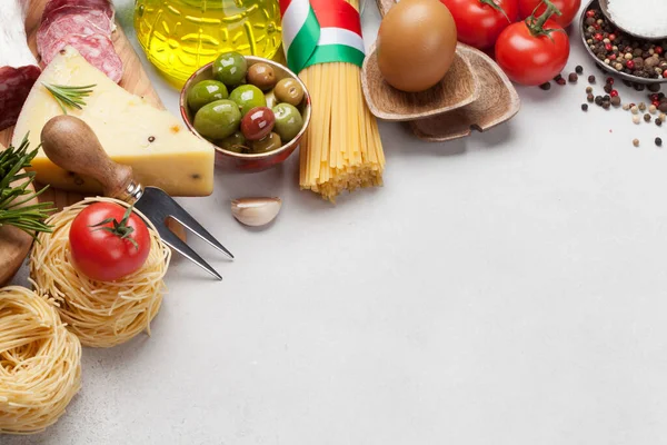 Olasz Konyha Élelmiszer Összetevők Tészta Sajt Szalámi Olajbogyó Paradicsom Kőasztalra — Stock Fotó