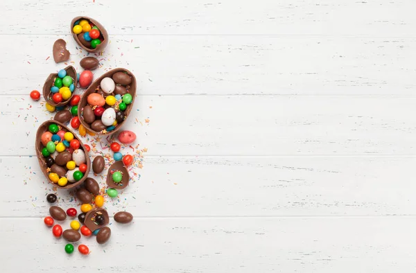 Schokolade Ostereier Und Bunte Süßigkeiten Auf Hölzerner Grußkarte Ansicht Von — Stockfoto