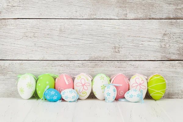 Wielkanocna Kartka Kolorowymi Pisankami Przed Drewnianą Ścianą Miejscem Twoje Pozdrowienia — Zdjęcie stockowe