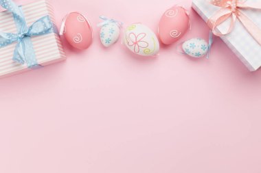 Paskalya tebrik kartı, hediye kutuları ve pembe arka planda renkli paskalya yumurtaları. Tebrik etmek için en üstteki dairede yer var.