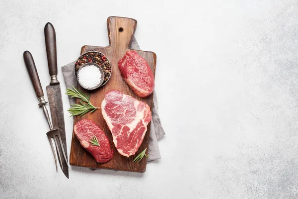 生鲜牛肉牛排的品种 切菜板上有调味品 带有复制空间的顶视图平面布局 — 图库照片