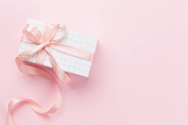 Pembe arka planda pastel renkli hediye kutusu olan tebrik kartı. Tebrik etmek için en üstteki dairede yer var.