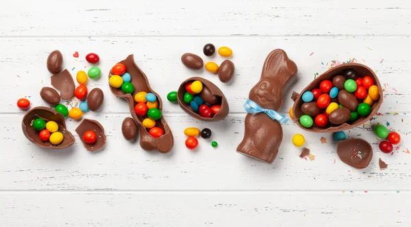 Schokoladen Ostereier Schokohase Und Bunte Süßigkeiten Auf Hölzerner Grußkarte Ansicht — Stockfoto