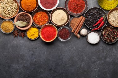 Koyu taş masada çeşitli baharatlar var. Hint mutfağı. Üst görünüm düzlüğü kopyalama alanı ile yatıyordu