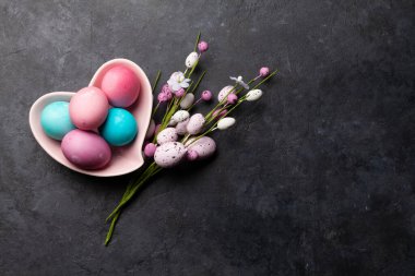 Paskalya tebrik kartı taştan arka planda renkli paskalya yumurtaları dekoru. Tebrik etmek için en üstteki dairede yer var.