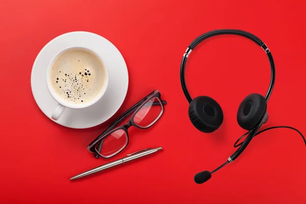 Ofis Kırmızısı Arkaplanı Kulaklık Kahve Fincanı Bardak Kalem Düz Yatıyordu — Stok fotoğraf