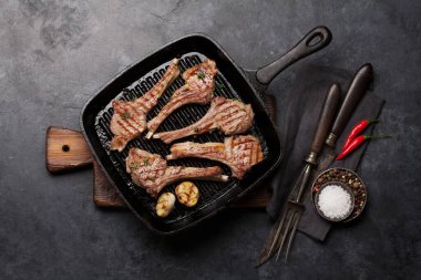 Kızarmış kuzu pirzolası. Baharatlı ve baharatlı kuzu pirzolası. Taş masadaki üst görünüm 