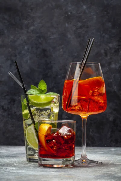 三个经典的鸡尾酒杯在木制桌子上 Negroni Aperol Spritz和Mojito 有复制空间 — 图库照片