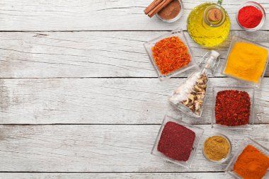 Beyaz ahşap masada çeşitli baharatlar var. Hint mutfağı. Üst görünüm düzlüğü kopyalama alanı ile yatıyordu
