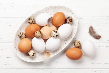 Tahta masada beyaz, kahverengi ve bıldırcın yumurtaları. Kopyalama alanı olan üst görünüm. Düz yatıyordu