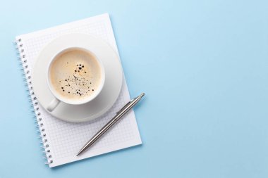 Ofis çalışma masası, not defteri ve kahve. Metnin için en üstte boşluk var. Düz yatıyordu