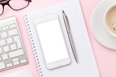 Bilgisayarlı, akıllı telefonlu, malzemeli ve kahveli pembe çalışma masası. Metnin ya da uygulaman için en üstteki görünüm. Düz yatıyordu