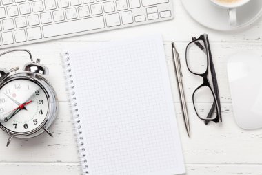 Ofis masasında bilgisayar, malzeme, kahve ve çalar saat var. Sabah ya da teslim tarihi konsepti. Metnin için en üstte boşluk var. Düz yatıyordu